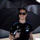 A photo of Mercedes driver Stoffel Vandoorne holding a black umbrella.